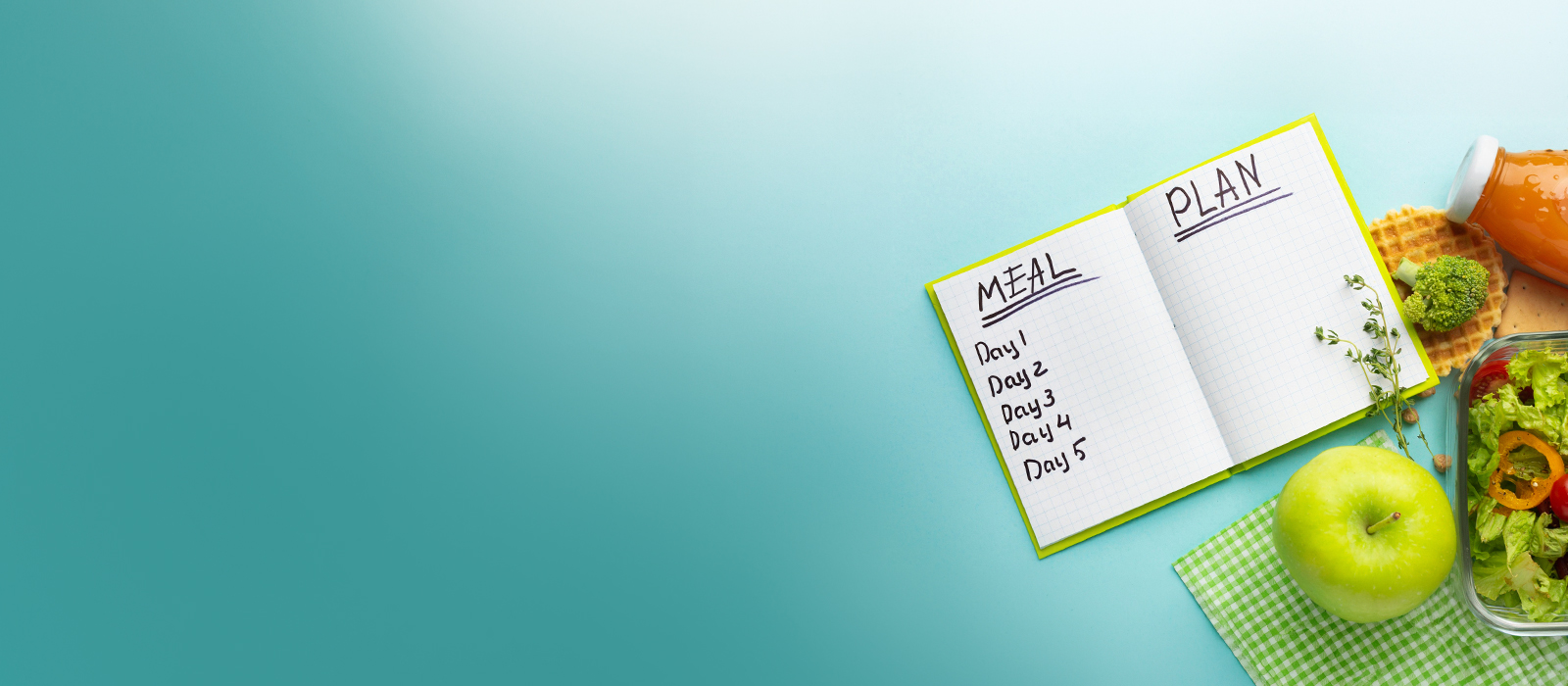 Meal plan notebook with five days listed, next to a green apple and fresh salad